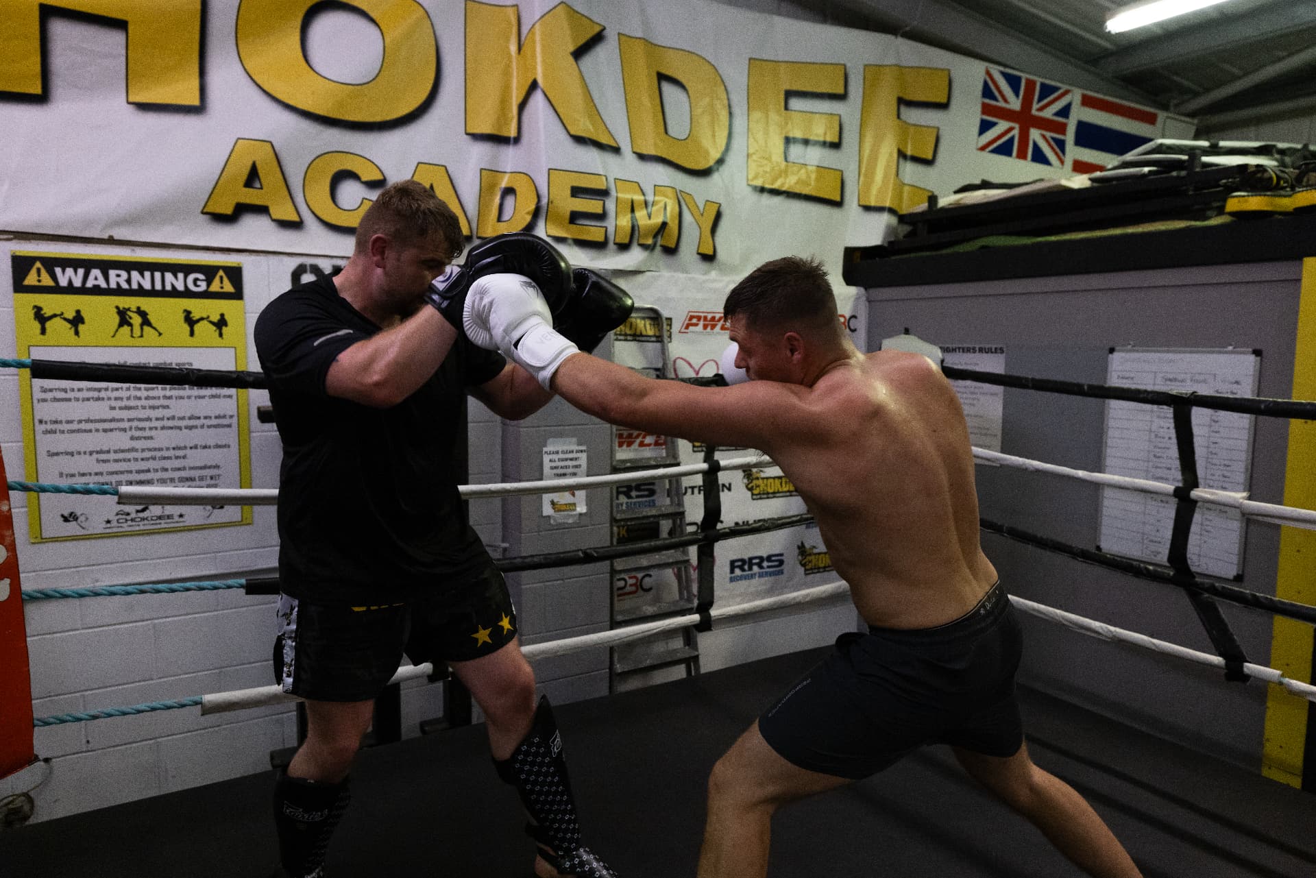 Member landing a straight punch on his partner's guard in the ring