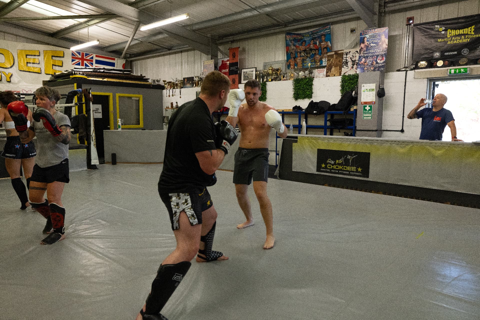Members sparring on the mats under the Chokdee Academy signage