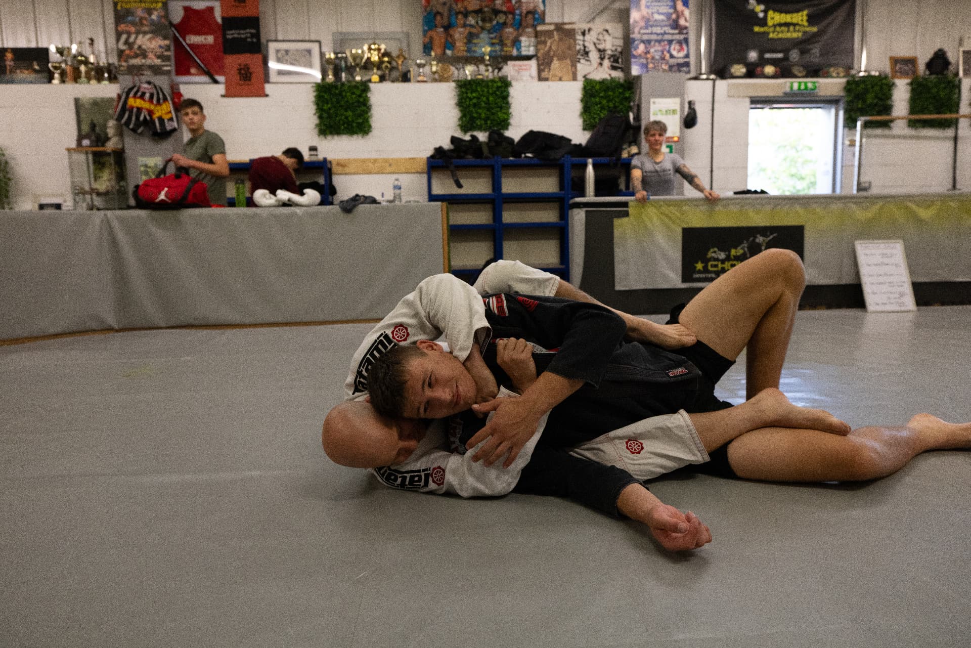 Two athletes rolling on the mats during a Brazilian Jiu-Jitsu session