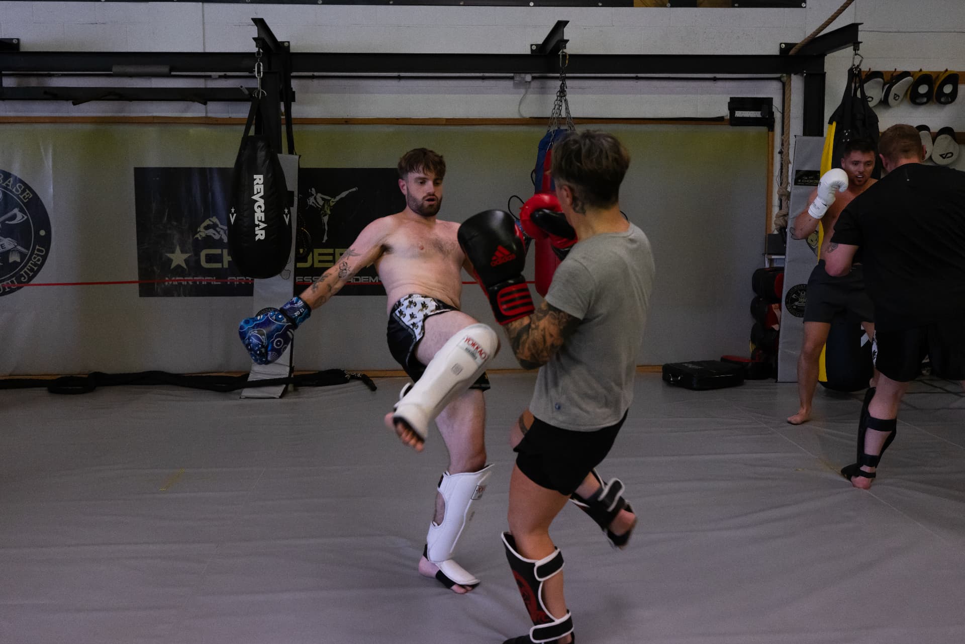 Coach drilling a teep against pads on the mats