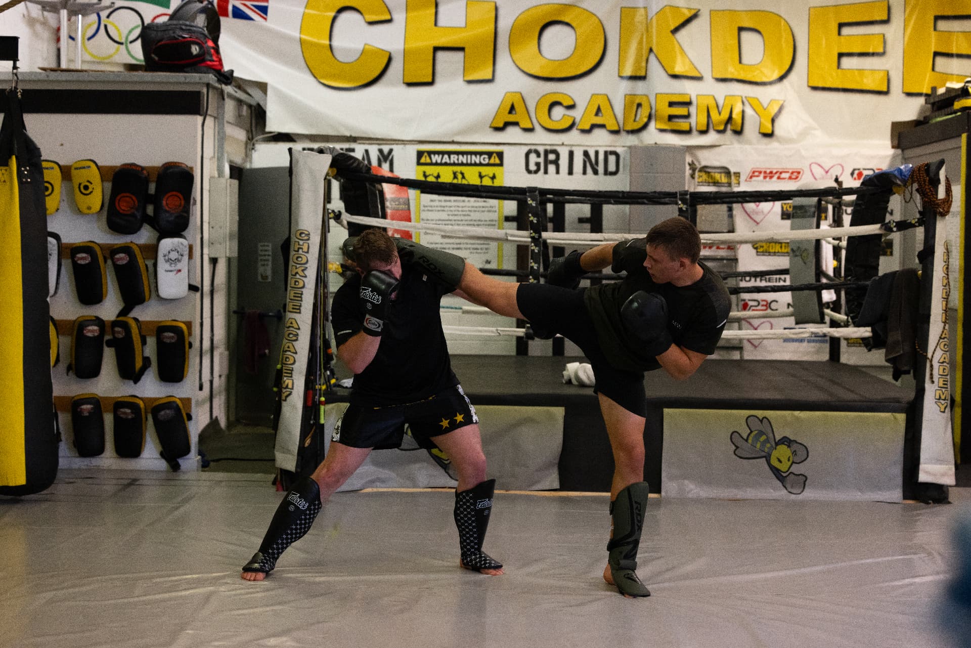 Member landing a body kick on his partner's block during Muay Thai sparring