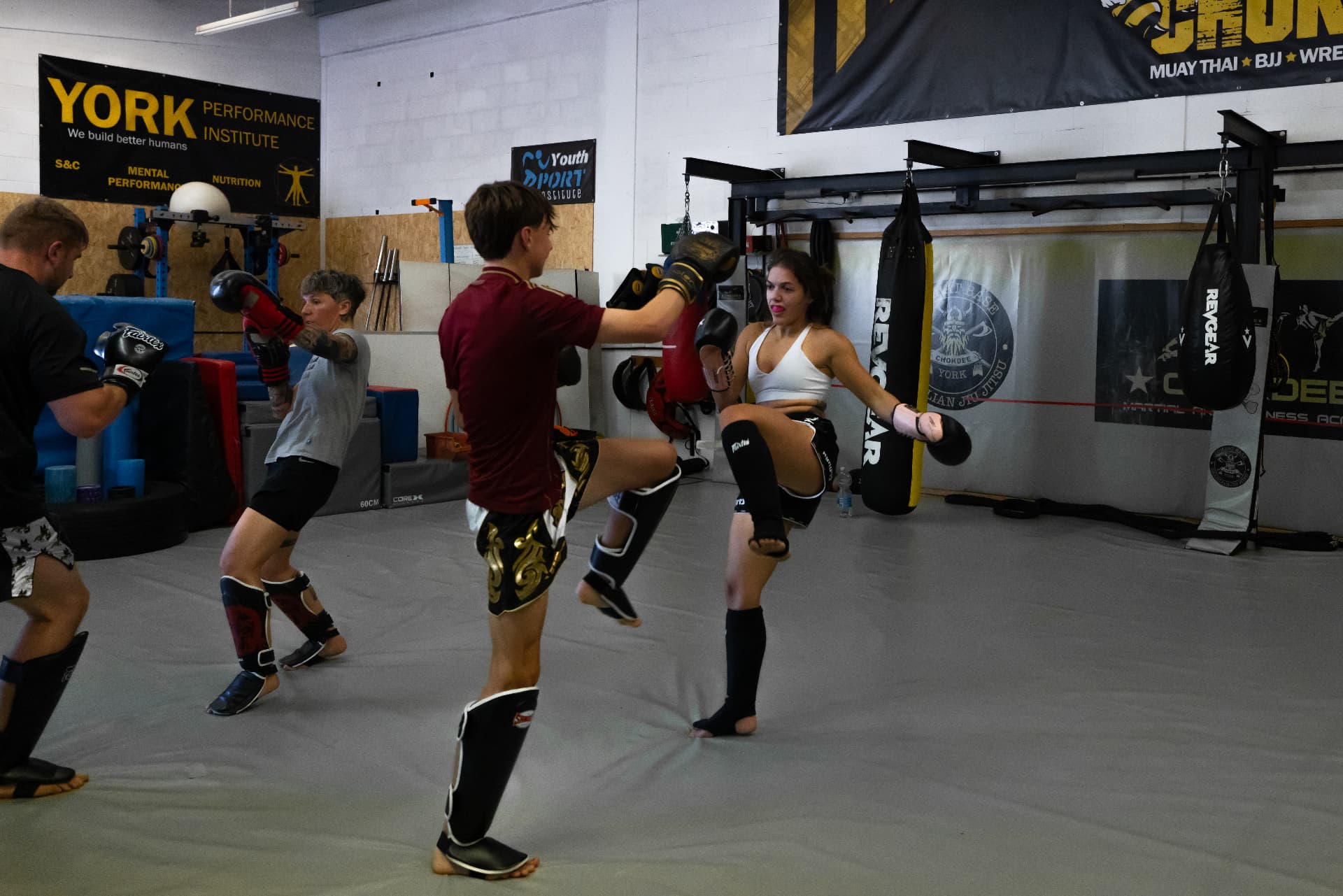 Member throwing a kick during a partner pad drill