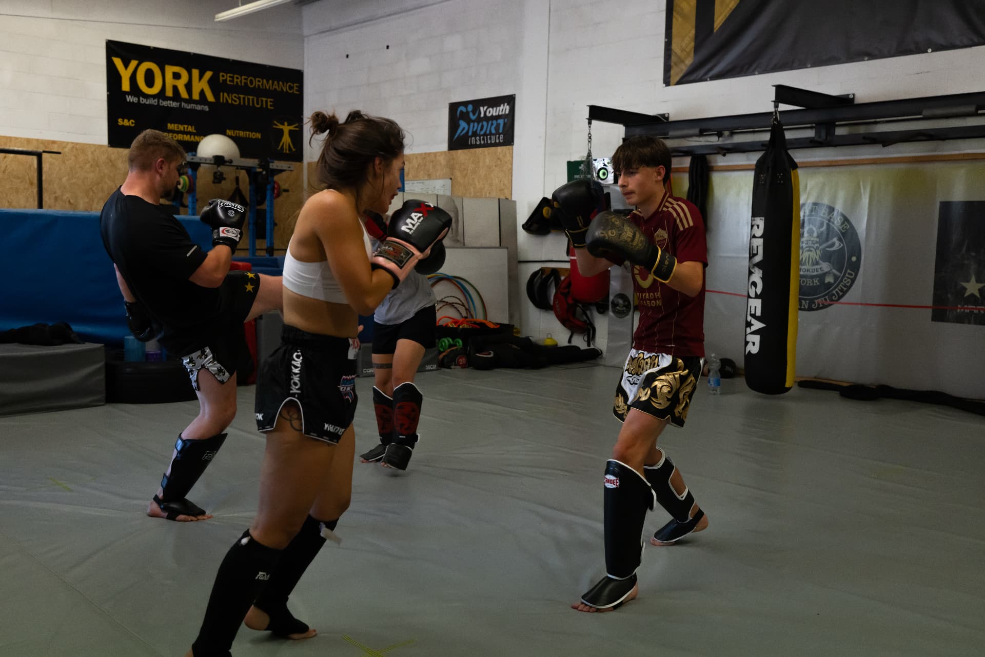 Members drilling kicks and pads in a Muay Thai class
