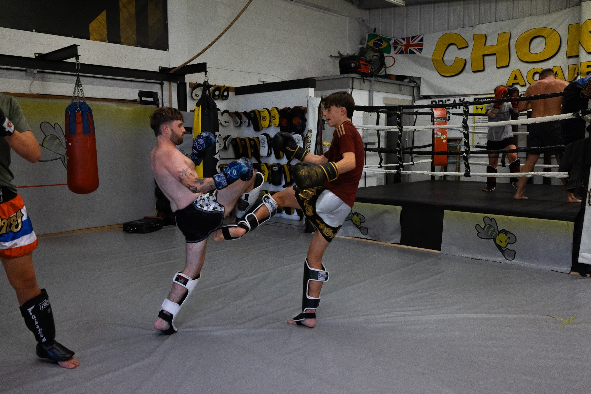 Two members exchanging kicks during a Muay Thai drill