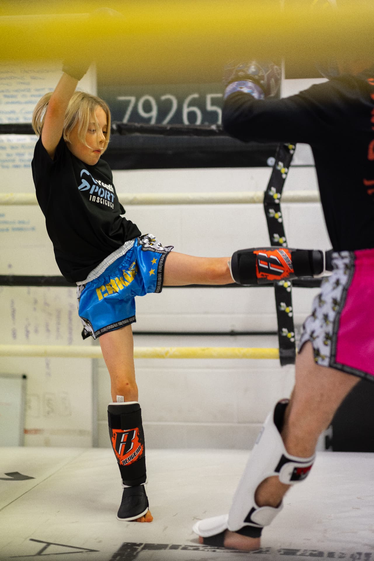 Junior member kicking pads in the ring